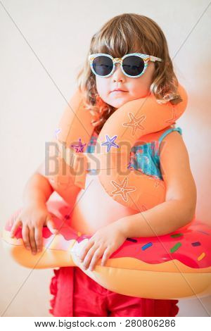 Adorable Little Girl Ready To Go For The Beach, Wearing Sunglasses, Inflatable Over-sleeves Floats A