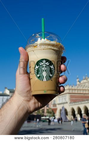 Krakow, Poland - May 10, 2018: Hand Holds A Starbak Cold Coffee Frappuchino In A Plastic Glass