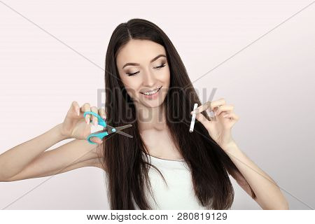 Stop Smoking. Quit Smoking Womens Hands Holding A Bunch Of Cigarettes And Cut Them In Half Scissors.