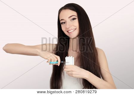Stop Smoking Concept. Young Woman Cut Cigarettes With Scissors Happy Smiling. Focus On Hand, Scissor