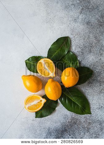 Orange Meyeri Lemons With Green Leaves In A Group On A Gray Background.