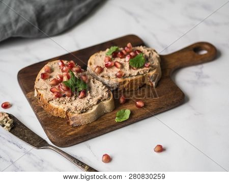 Two Toasts Duck With Prunes Rillettes Pate On White Bread With Pomegranate Seeds On A Wood Board On 