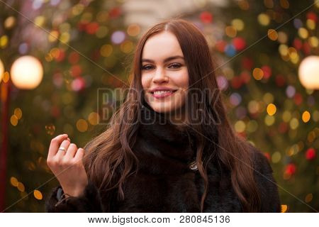 Portrait of a Young beautiful brunette woman in mink fur coat, posing in winter Red Square in central Moscow