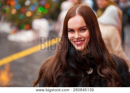 Portrait of a Young beautiful brunette woman in mink fur coat, posing in winter Red Square in central Moscow
