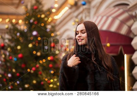 Portrait of a Young beautiful brunette woman in mink fur coat, posing in winter Red Square in central Moscow