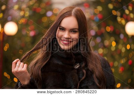 Portrait of a Young beautiful brunette woman in mink fur coat, posing in winter Red Square in central Moscow
