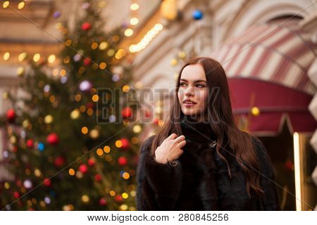 Portrait of a Young beautiful brunette woman in mink fur coat, posing in winter Red Square in central Moscow