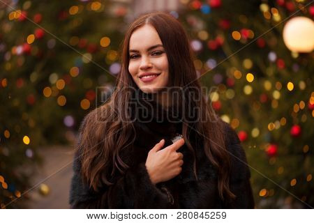 Portrait of a Young beautiful brunette woman in mink fur coat, posing in winter Red Square in central Moscow