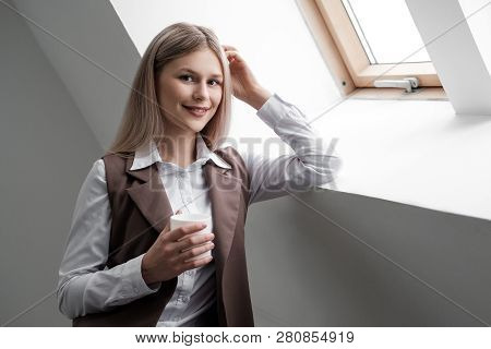 Blonde Girl In A Business Suit Works On A Computer In A White Bright Office.
