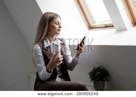 Blonde Girl In A Business Suit Works On A Computer In A White Bright Office.