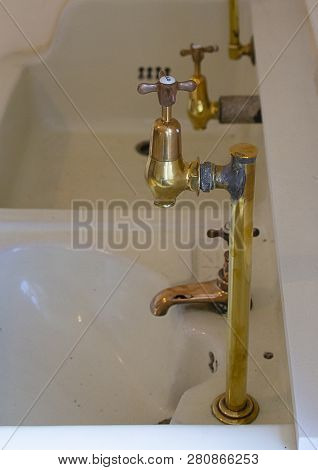 Old Hospital Brass Taps And White Ceramic Sinks Side View