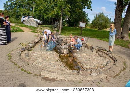 Aglona, Latvia - September 2,2018: A People Pouring The Holy Water In A Bottles From The Holy Spring