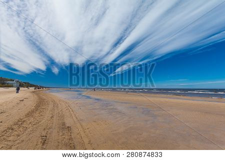 Jurmala, Latvia - May 7, 2017: People Are Walking  On Sandy Beach On The Baltic Sea In Jurmala In La