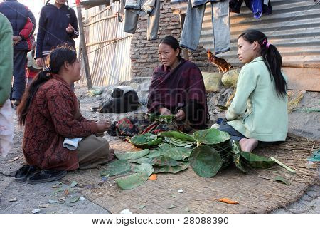 KATHMANDU, NEPAL - Joulukuu: Naisten tehdään ruokia syödä köyhällä alueella on vanha Ban lehdistä