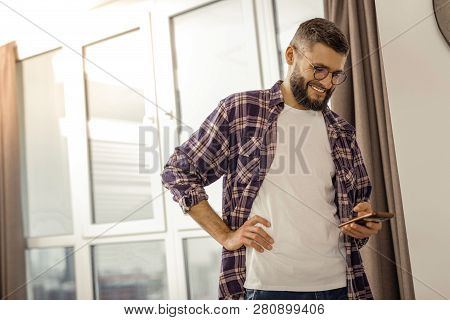 Tall Bearded Dark-haired Man In A Checkered Shirt Feeling Good