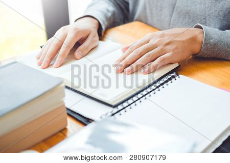 High School Or College Students Studying And Reading Together In Library