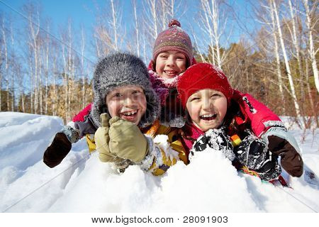 Rüzgârla oluşan kar yığını dışında içinde oynarken gülmekten winterwear mutlu çocuk