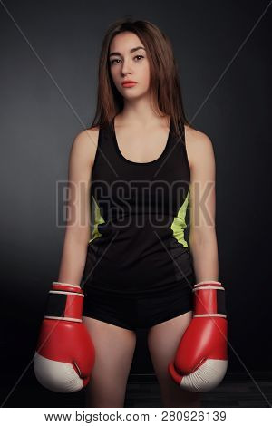 Young Fitness Girl With Bloxing Gloves Looking At Camera Over Black Background Art