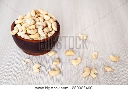 Peeled Cashew  In A Cedar Pine Plate On A Wooden Isolated Background. Row Of Bowls With Cashew   Nut