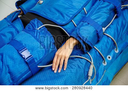 Hand Of Woman Lying Down During Pressotherapy Treatment. Weight Loss Pressure Therapy In Beauty Salo