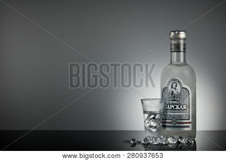 St.Petersburg, Russia - December 2018 - Bottle of cold vodka Czar's with ices and shot glass on a grey background with reflection. Premium vodka.  Produced in Russia. Original russian recipe