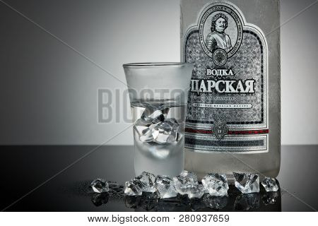 St.Petersburg, Russia - December 2018 - Bottle of cold vodka Czar's with ices and shot glass on a grey background with reflection. Premium vodka.  Produced in Russia. Original russian recipe