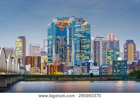 Osaka, Japan skyline on the Yodogawa River at twilight.