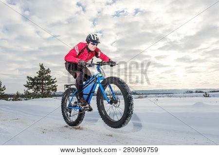Fat Bike Rider In Winter. Cycling. A Young Man Riding Fat Bicycle In The Winter. Fat Tire Bike.