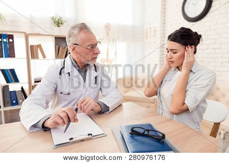 Doctor And Patient In Office. Doctor Is Old Caucasian Man. Patient Is Young Caucasian Woman. Woman I