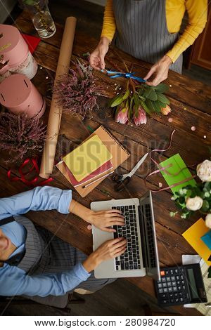 Above View Background Of Shopkeeper Using Laptop Over Wooden Table In Florists Shop