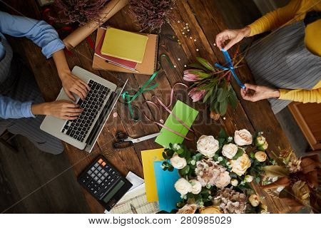 Above View Background Of Shopkeeper Using Laptop Over Wooden Table In Florists Shop, Copy Space