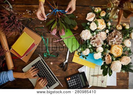 Above View Background Of Shopkeeper Using Laptop Over Wooden Table In Flower Shop, Copy Space