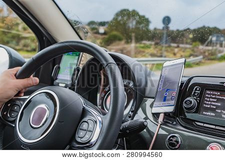 Adrano, Catania Italy - 01 18 2019: A Man Drives A Car Using Two Navigators For The Route And It Rai