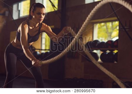 Fit, Sporty And Athletic Sportswoman Working In A Gym. Woman Training Using Battle Ropes. Sports, At