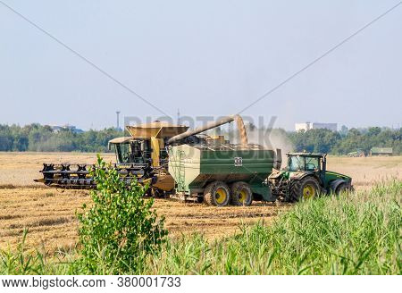 Ukraine, Kalush, August 2020: Harvesting Wheat By Modern Technologies. Overloading Wheat From The Co