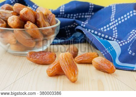 Group Of Dried Sweet Deglet Nour Date Fruites In Translucent Bowl And Dark Blue Napkin.organic Veget