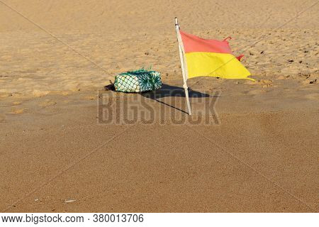 Red And Yellow Rescue Flag On The Beach. Warning Flags On The Beach