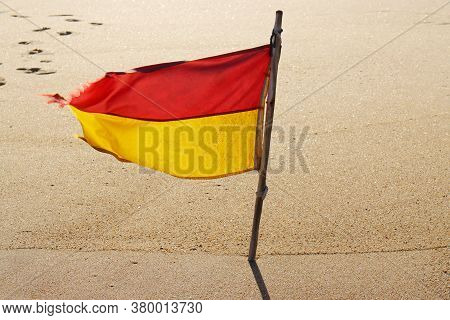 Red And Yellow Rescue Flag On The Beach. Warning Flags On The Beach