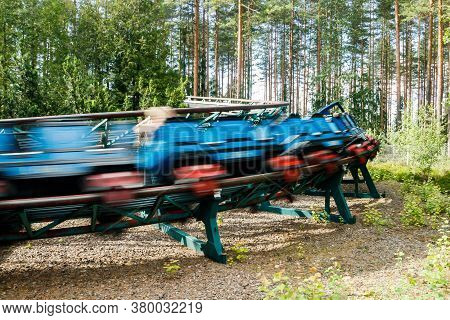 Ride Roller Coaster In Motion In Amusement Park At Summer Day