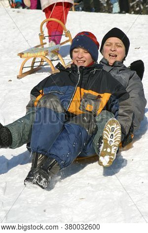 ZAGREB, CROATIA - JANUARY 12, 2014: Landscape view of a snowy hill with families with children and people sledging and having fun in snow, Park Maksimir in Zagreb, Croatia