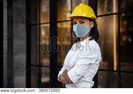 Portrait Of A Confident Construction Engineer Woman. Wearing Surgical Protection Mask And Looking At
