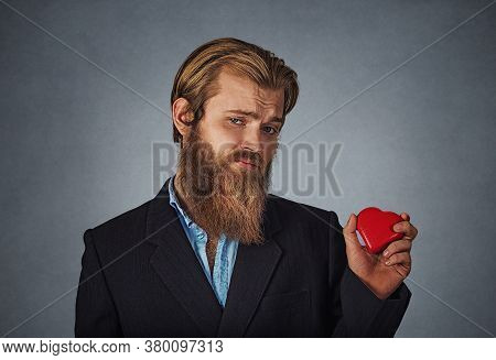 Sad Unhappy Skeptical Hipster Businessman In Black Jacket, Blue Shirt Standing And Holding Red Big H