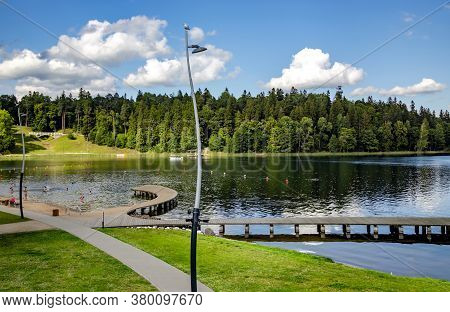 Latvia, Aluksne, August, 2020 - Wooden Pier Next To The City Beach On A Beautiful Large Lake In Aluk