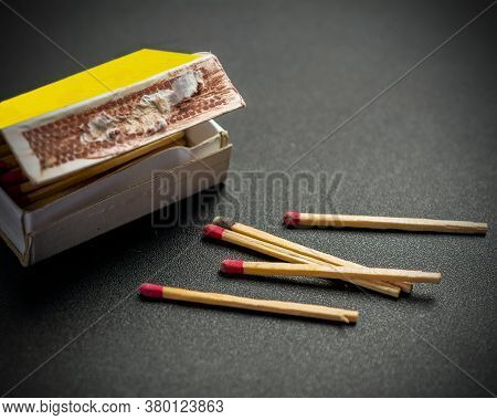 A Bad Box Of Matches With The Side Damaged And Five Failed Matches Against Black Background