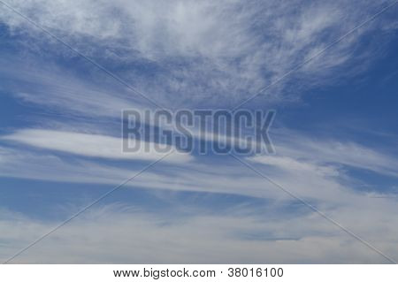 Spindrift skyer i den blå himmel