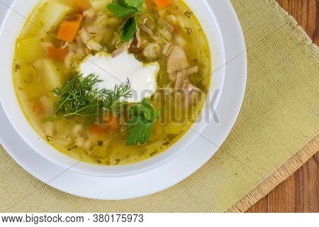 Serving Of Rassolnik - Meat Soup With Pearl Barley And Pickled Cucumbers Seasoned With Sour Cream, F