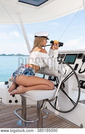 Attractive Blonde At The Wheel Of A Yacht