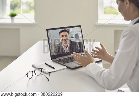 Online Medical Service. Female Doctor Giving Virtual Consultation To Businessman On Laptop. Gp Talki