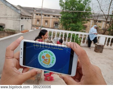District Katni, India - May 23, 2020: Woman Holding Smart Phone With Pradhan Mantri Matru Vandana Yo