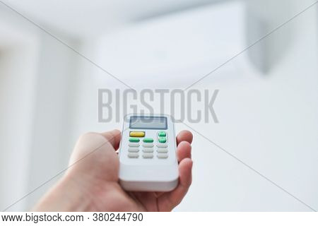 Air Condition Remote Control. Hand With Room Conditioner Remote Control. Air Temperature Switch For 